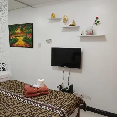 a bedroom with a bed and a flat screen tv at Birch Tower by the Bay Studio type in Manila