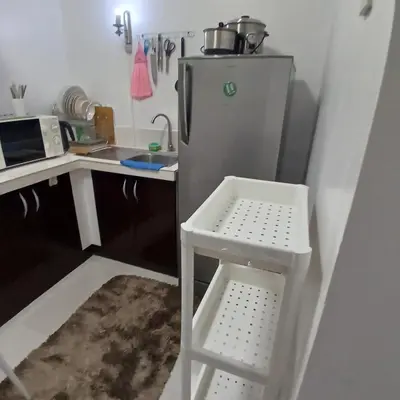 a small kitchen with a refrigerator and a stool at Birch Tower by the Bay Studio type in Manila