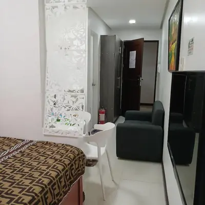 a room with a bed and a chair and a desk at Birch Tower by the Bay Studio type in Manila