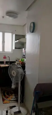 a kitchen with a white refrigerator and a clock on the wall at Birch Tower by the Bay Studio type in Manila
