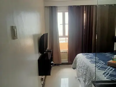 a hotel room with a bed and a window at Birch Tower by the Bay Studio type in Manila