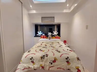 a bedroom with a bed with stuffed animals on it at 1BR Mickey Mouse Theme BGC Forbeswood Parklane in Manila