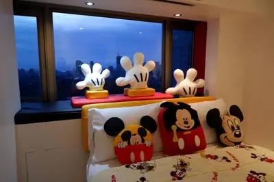 a group of stuffed animals sitting on top of a bed at 1BR Mickey Mouse Theme BGC Forbeswood Parklane in Manila