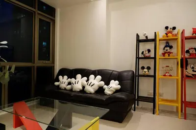 a living room with a couch with stuffed animals on it at 1BR Mickey Mouse Theme BGC Forbeswood Parklane in Manila