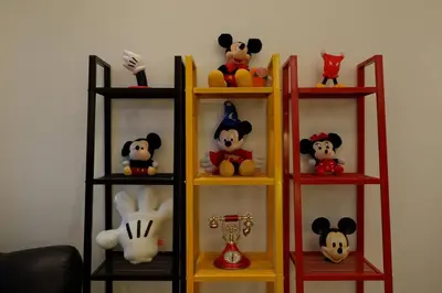a shelf with various stuffed animals on it at 1BR Mickey Mouse Theme BGC Forbeswood Parklane in Manila