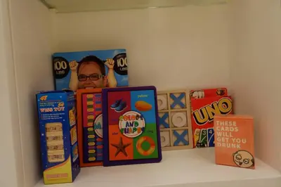a shelf with books and other toys on it at 1BR Mickey Mouse Theme BGC Forbeswood Parklane in Manila