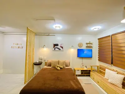 a bedroom with a large bed and a flat screen tv at Fablo Getaway in Santa Rosa