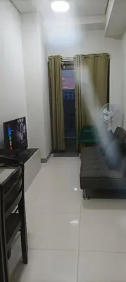 a room with a couch and a desk and a window at Charlie's Penthouse in Mall of Asia Complex in Manila