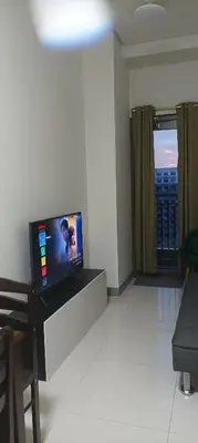 a living room with a flat screen tv on a counter at Charlie's Penthouse in Mall of Asia Complex in Manila