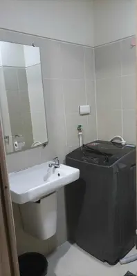 a bathroom with a sink and a toilet and a mirror at Charlie's Penthouse in Mall of Asia Complex in Manila