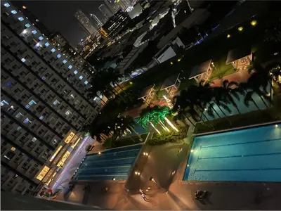 a view of a city at night with tall buildings at Cozy 1BR Condo at SM Lights Mandaluyong City in Manila