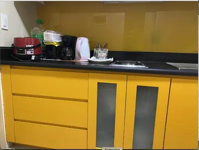 a kitchen with yellow cabinets and a sink at Cozy 1BR Condo at SM Lights Mandaluyong City in Manila