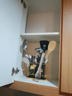 a cupboard with dishes and utensils in it at Dmjs staycation in Manila
