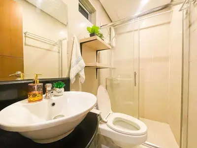 a bathroom with a white sink and a toilet at Prime Condo Living Near Venice Canal #msert26k in Manila