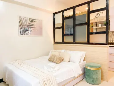 a small bedroom with a white bed and some windows at Prime Condo Living Near Venice Canal #msert26k in Manila