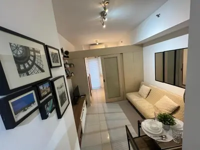 a living room with a couch and a table at Makati High rise 1 Bedroom Condo with Balcony in Manila