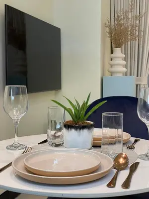 a table with plates and glasses on a table at Chic and modern studio in Manila