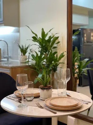 a table with plates and wine glasses on it at Chic and modern studio in Manila