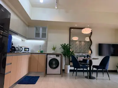 a kitchen with a dishwasher and a table and chairs at Chic and modern studio in Manila