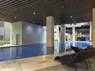 a swimming pool with a chair in a building at Home Away From Home - S Residences in Manila