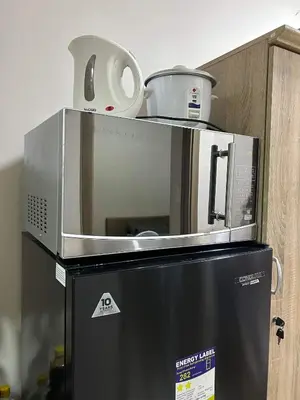 a microwave oven sitting on top of a refrigerator at Home Away From Home - S Residences in Manila