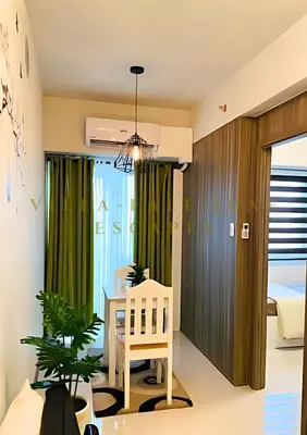 a bedroom with green curtains and a table with a chair at 1 Bed Room Coast Residence at Heart of Metro Manila - Pasay City in Manila