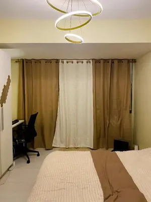 a bedroom with a bed and a chandelier at Azure Staycation by the clouds in Manila