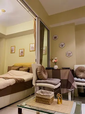 a bedroom with two beds and a glass table at Azure Staycation by the clouds in Manila