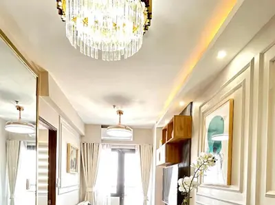 a room with a chandelier and a room with a table at Golden Scape 1 Bedroom near NAIA Airport in Manila