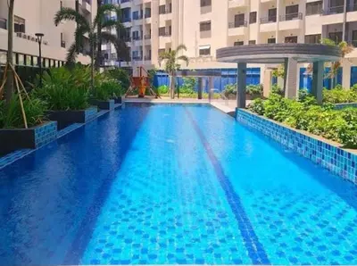 a large blue swimming pool in front of a building at Golden Scape 1 Bedroom near NAIA Airport in Manila