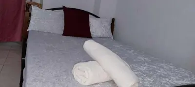 a bed with a pile of towels on it at Marco's Economy Room For Rent near NAIA in Manila