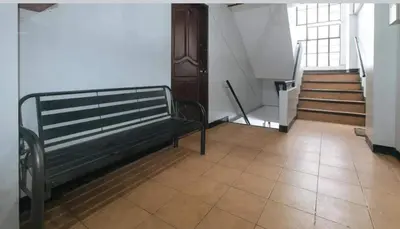 a hallway with a bench in a building with stairs at Marco's Economy Room For Rent near NAIA in Manila