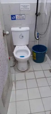 a small bathroom with a toilet and a bucket at Marco's Economy Room For Rent near NAIA in Manila