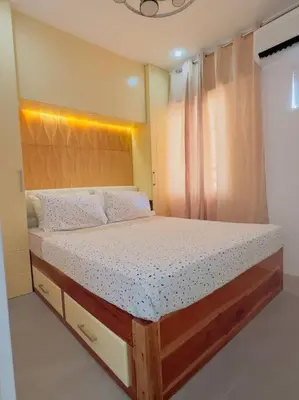 a bedroom with a large bed with a wooden frame at Homestay at Phirst Park Homes Tanza in Tanza