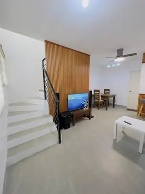a living room with a staircase and a television at Homestay at Phirst Park Homes Tanza in Tanza