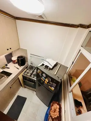 a small kitchen with a stove and a refrigerator at Homestay at Phirst Park Homes Tanza in Tanza