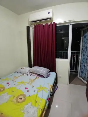 a small bedroom with a bed with a blanket at Breeze Residences in Manila