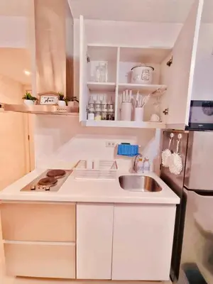 a white kitchen with a sink and a refrigerator at Azure Staycation by Oveecation Suites in Manila