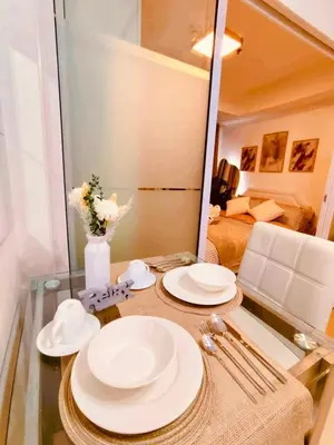 a table with plates and a mirror in a room at Azure Staycation by Oveecation Suites in Manila