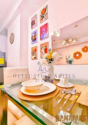 a glass table with plates and utensils on it at Azure Staycation by Oveecation Suites in Manila