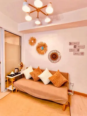 a living room with a couch and mirrors on the wall at Azure Staycation by Oveecation Suites in Manila