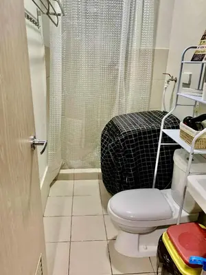a small bathroom with a toilet and a shower at MG Place -2 BR condo unit at SMDC Charm Residences, Cainta, Rizal, 1900 in Cainta