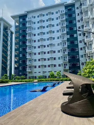 a hotel with a swimming pool in front of a building at MG Place -2 BR condo unit at SMDC Charm Residences, Cainta, Rizal, 1900 in Cainta