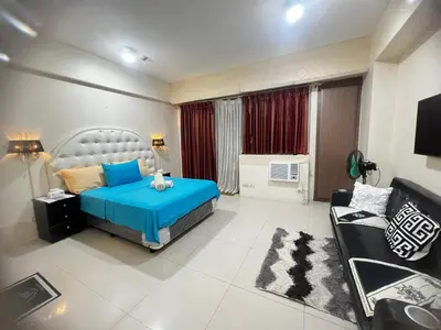 a bedroom with a blue bed and a couch at one palm tree villas &two palm tree villas in Manila