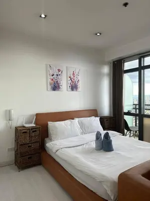 a bedroom with a bed with two blue shoes on it at Gramercy Studio on 52nd Floor Rockwell View Free WiFi in Manila