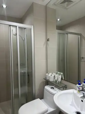 a bathroom with a shower and a toilet and a sink at Gramercy Studio on 52nd Floor Rockwell View Free WiFi in Manila