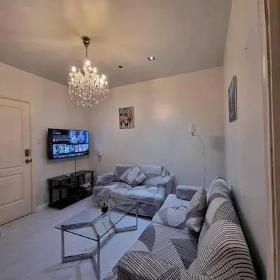 a living room with a couch and a chandelier at Gramercy Residences Two Bedroom on 60th Floor in Manila