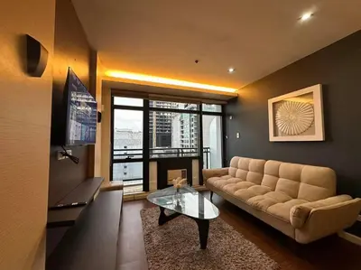a living room with a couch and a glass table at Spacious 1 Bedroom in Gramercy 2 balconies in Manila