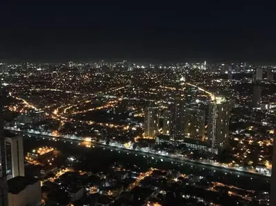 a view of a city lit up at night at 66F 1 BR Penthouse with 2 Balconies Panoramic View in Manila