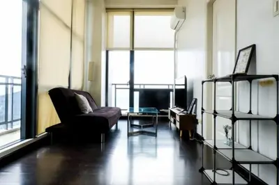 a living room with a couch and a chair at 66F 1 BR Penthouse with 2 Balconies Panoramic View in Manila